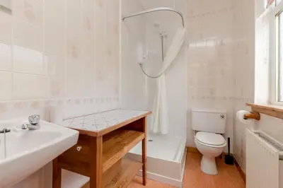 a bathroom with a sink and a toilet and a tub at Foxglove Cottage in Maybole