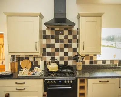 a kitchen with a stove and a stove top oven at Auchnabreac Cottage in Carradale