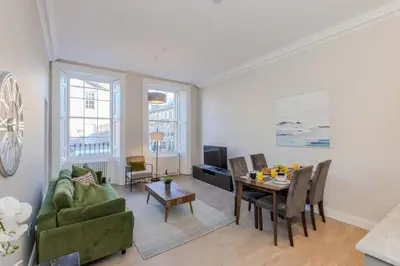 a living room with a green couch and a table at Dragon Suites - Edinburgh City Centre 2 Bed Apartment in Edinburgh