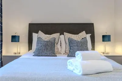 a bedroom with a bed with blue and white pillows at Dragon Suites - Edinburgh City Centre 2 Bed Apartment in Edinburgh