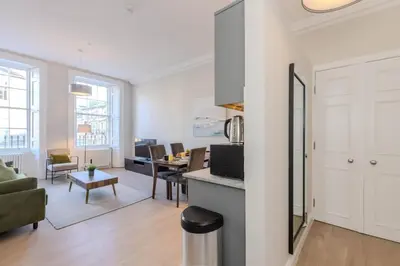 a living room with a kitchen and a dining room at Dragon Suites - Edinburgh City Centre 2 Bed Apartment in Edinburgh