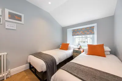 two beds in a room with a window at City Centre, Newly Refurbished Stylish Apartment in Edinburgh