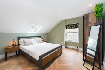 a bedroom with a bed and a mirror at City Centre, Newly Refurbished Stylish Apartment in Edinburgh