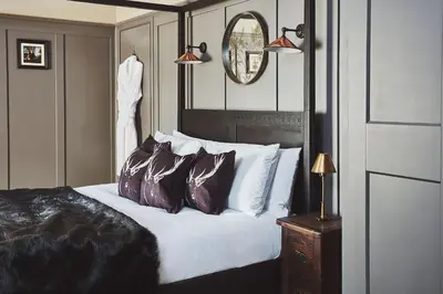a bedroom with a bed with pillows and a mirror at No.26 By The Sea in Oban