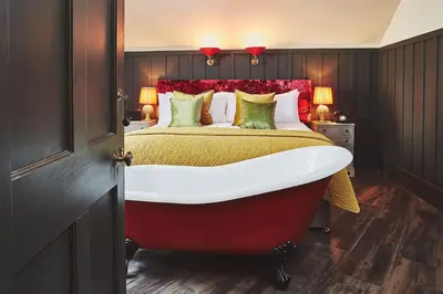 a bedroom with a large bed with a red headboard at No.26 By The Sea in Oban