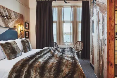a bedroom with a bed and a large window at No.26 By The Sea in Oban