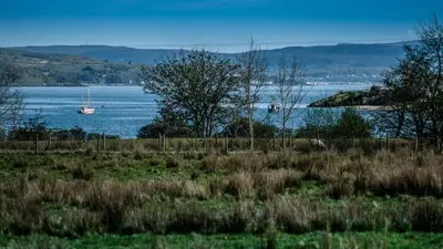 a boat in a large body of water at The Ashcroft Sea View 6 in Dunoon