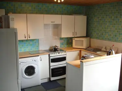 a kitchen with a washing machine and a washer at RoSE COTTAGE THREE BEDROOM HOUSE WITH PARKING Christmas Special in Carsphairn