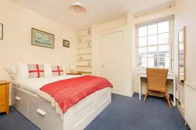 a bedroom with a bed and a desk and a window at JOIVY Gorgeous 2-bed flat near Edinburgh Castle in Edinburgh