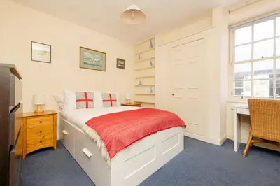 a bedroom with a bed and a desk and a window at JOIVY Gorgeous 2-bed flat near Edinburgh Castle in Edinburgh