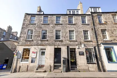 an old stone building on the corner of a street at JOIVY Gorgeous 2-bed flat near Edinburgh Castle in Edinburgh