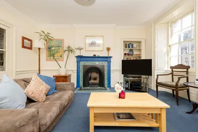 a living room with a couch and a fireplace at JOIVY Gorgeous 2-bed flat near Edinburgh Castle in Edinburgh