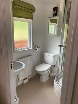 a bathroom with a toilet and a sink and a window at Lochay Lodges in Killin