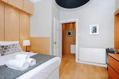 a bedroom with a bed with towels on it at JOIVY Lovely Flat in the Heart of Edinburgh in Edinburgh