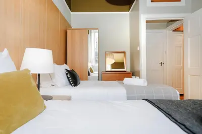 a bedroom with two beds and a lamp at JOIVY Lovely Flat in the Heart of Edinburgh in Edinburgh