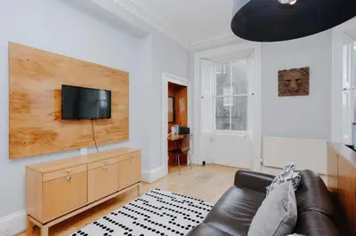 a living room with a couch and a flat screen tv at JOIVY Lovely Flat in the Heart of Edinburgh in Edinburgh