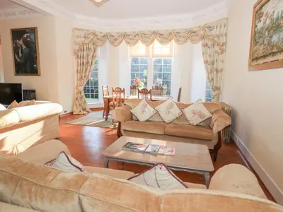 a living room with two couches and a table at Auchentroig House in Stirling