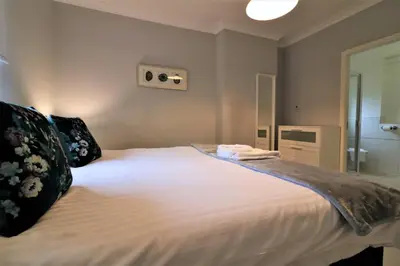 a bedroom with a large white bed and a bathroom at Signature - Moss View in Govan