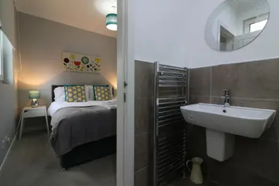 a small bathroom with a sink and a bed at Signature - Moss View in Govan