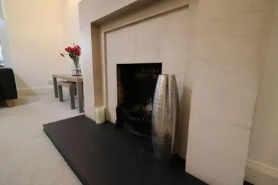 a living room with a fireplace with a vase at Signature - Moss View in Govan