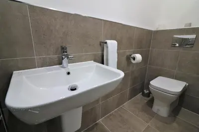 a bathroom with a white sink and a toilet at Signature - Moss View in Govan