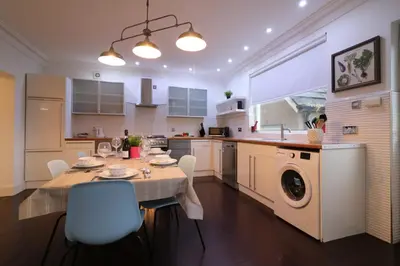 a kitchen with a dining table and a washing machine at Signature - Moss View in Govan