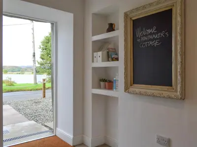 a room with a chalkboard on a wall with a mirror at Printmakers Cottage in Bellanoch