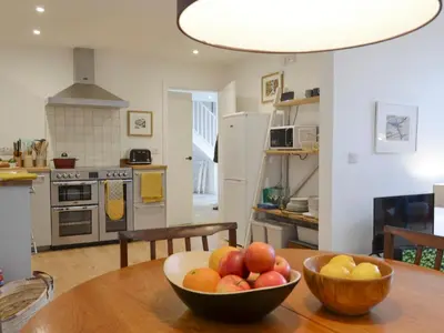 a bowl of fruit on a wooden table in a kitchen at Printmakers Cottage in Bellanoch