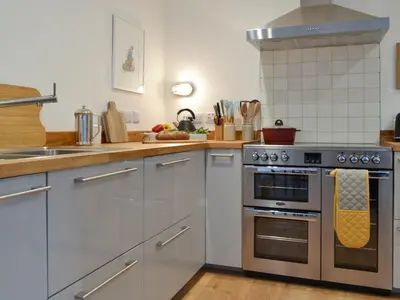 a kitchen with a stove and a sink at Printmakers Cottage in Bellanoch