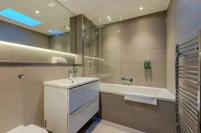 a bathroom with a sink and a bath tub at Dragon Suites - Edinburgh City Centre 2 Bed Apartment in Edinburgh