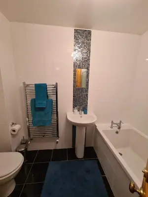 a bathroom with a sink and a tub and a toilet at The Editor's Choice, Oban seafront apartment in Oban