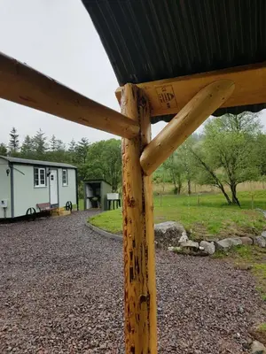a wooden post with a house in the background at Wee Highland Hideaway Hut in Dalmally