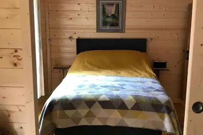 a bedroom with a bed in a wooden cabin at Off Grid 1-Bed Cabin Pets Ok 20 mins to Dunoon in Blairmore