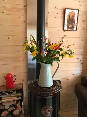 a vase filled with flowers on top of a table at Off Grid 1-Bed Cabin Pets Ok 20 mins to Dunoon in Blairmore