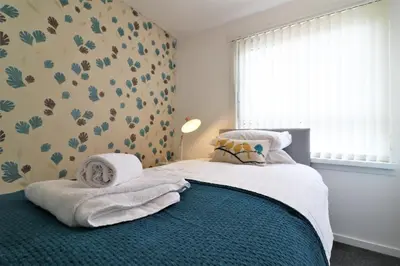 a bedroom with a bed with towels on it at Signature - Troon View in East Kilbride
