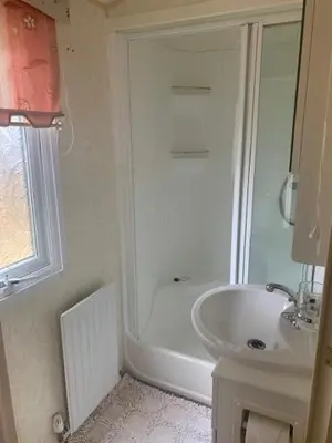 a white bathroom with a shower and a sink at Lyndhurst Corner 72 in Dunoon