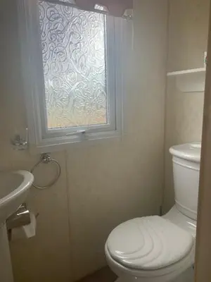 a bathroom with a white toilet and a window at Lyndhurst Corner 72 in Dunoon