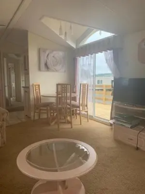 a living room with a table and a dining room at Lyndhurst Corner 72 in Dunoon