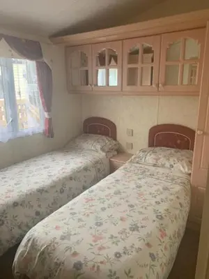 a small bedroom with two beds and a cabinet at Lyndhurst Corner 72 in Dunoon