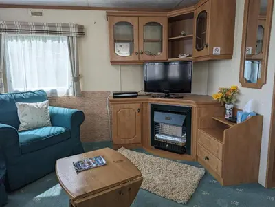 a living room with a tv and a couch and a table at 34 Glenfinart Park in Dunoon