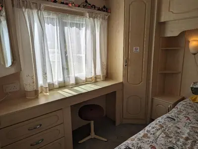 a bedroom with a desk in front of a window at 34 Glenfinart Park in Dunoon