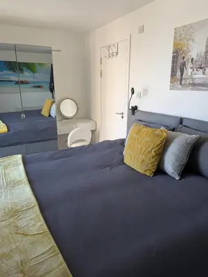 a bedroom with a blue bed and a mirror at Glasgow City Centre Waterfront Apartment in Glasgow