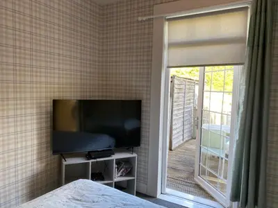 a bedroom with a flat screen tv and a window at Nairoo in Balloch