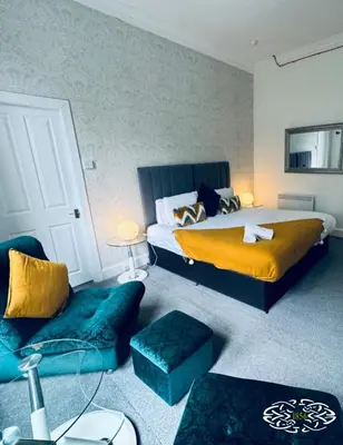 a bedroom with a bed and a couch at Royal Marine Hotel Dunoon in Kirn