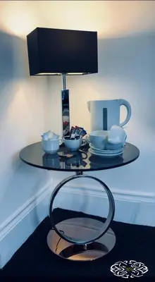 a glass table with bowls and a lamp on it at Royal Marine Hotel Dunoon in Kirn