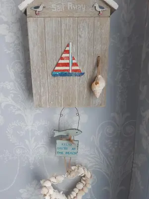 a wall with a sign with a sail ship and a rope at Ardgowan Cottage in Brodick