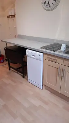a kitchen with a counter and a white dishwasher at Ardgowan Cottage in Brodick
