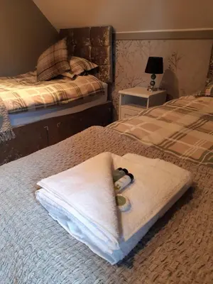 a pile of towels sitting on top of a bed at Ardgowan Cottage in Brodick