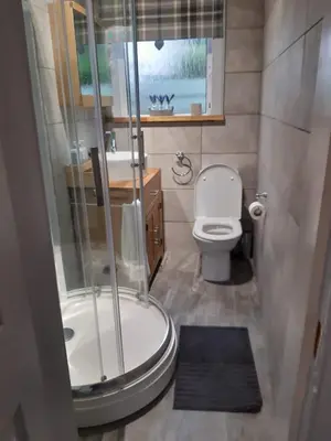 a small bathroom with a shower and a toilet at Ardgowan Cottage in Brodick