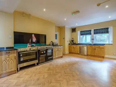 a large kitchen with stainless steel appliances and a television at The Old Nunnery - Uk7122 in Skelmorlie